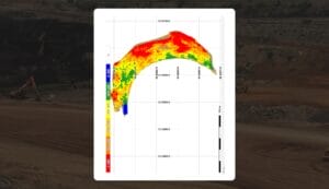 A colorful heat map overlay on an excavation site showing varying data levels. The map is predominantly red and yellow with some green and blue areas, indicating different intensities. Background features construction machinery and dug earth.