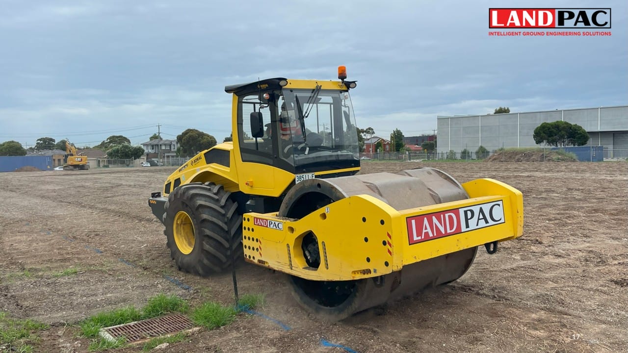 A yellow road roller with “LANDPAC” branding on a construction site.